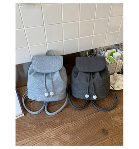 Detail view of light and dark grey textured fabric backpacks with drawstring closure
