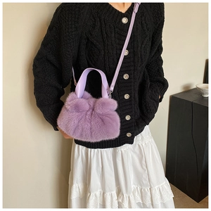 Sac seau en fausse fourrure lilas porté en bandoulière pour un look chic d'hiver
