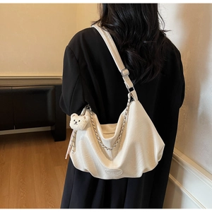Détail du sac hobo blanc plissé avec chaîne en métal et breloque ourson mignon