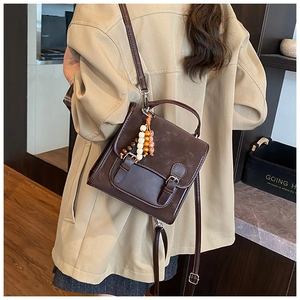 Detail of vintage coffee brown backpack with matte texture and decorative wooden beads