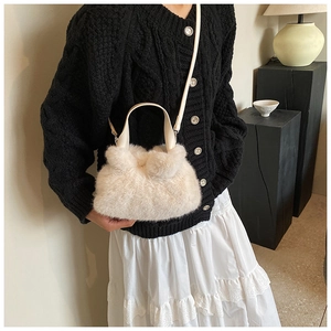 Détail du sac seau en fausse fourrure crème avec bandoulière amovible en cuir fin