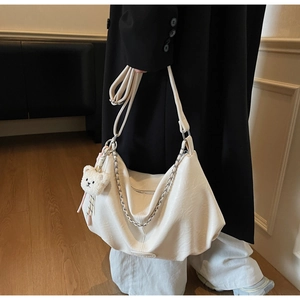 Détail du sac hobo en cuir PU blanc cassé avec bandoulière chaîne et breloque ours en peluche