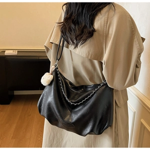 Détail du grand sac cabas noir en similicuir avec chaîne en métal et breloque ours