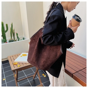Macro shot of dark brown frosted suede tote bag featuring a spacious open structure