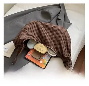 Interior view of checkered crescent bag showing large capacity for tablet and cosmetics