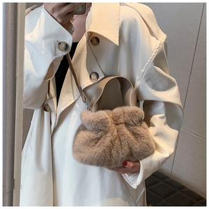 Détail du sac seau en fausse fourrure beige avec poignées et bandoulière