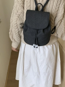 Black minimalist bucket backpack with drawstring and marble bead detail for women