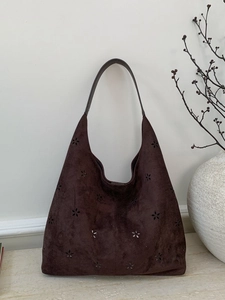 Dark brown faux suede tote bag with laser-cut floral patterns and a spacious hobo design