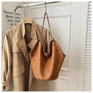 Brown frosted leather tote bag detail hanging with an autumn trench coat