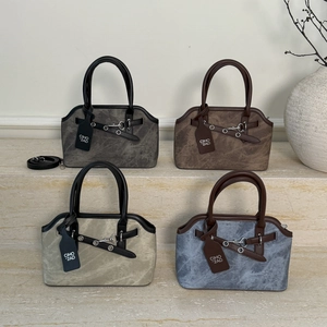 Retro handbags in four colors with horsebit hardware and vintage textures on stone steps
