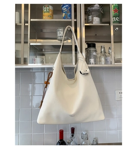 Detail of white Hobo tote bag with Pantor London logo and wooden bead charm accessory
