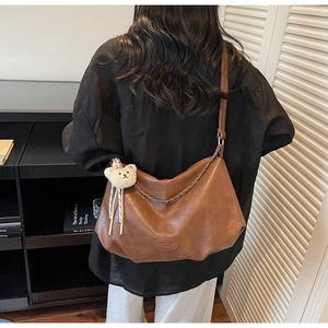 Vue détaillée du sac bandoulière en cuir PU marron avec chaîne en métal et breloque ours