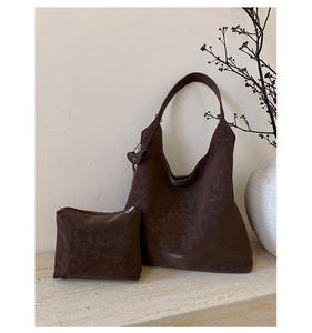 Detailed close-up of brown suede tote bag with matching zippered pouch and textured finish