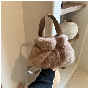 Vue détaillée du sac seau en fausse fourrure pelucheuse avec anse en cuir marron et coutures