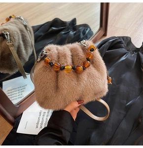 Detail der Plüsch-Beuteltasche mit bernsteinfarbenem Perlengriff und Kordelzugverschluss