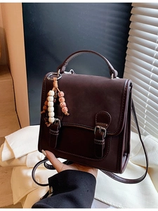 Retro dark brown backpack with decorative bead pendant and adjustable straps