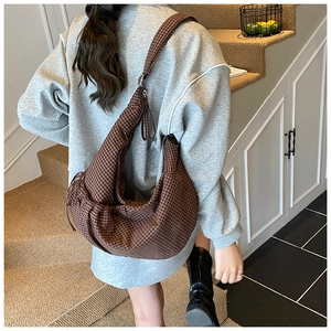 Brown checkered hobo bag shown from above on a shoulder to display large storage capacity