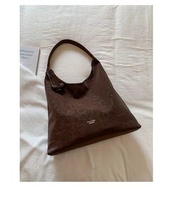 Detail of dark brown vintage texture on hobo bag with white brand lettering