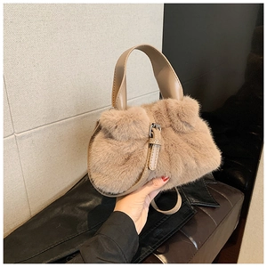 Détail d'un sac seau en peluche kaki avec poignée en cuir et boucle métallique dorée