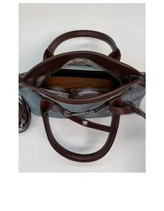 Spacious interior of gray canvas tote with leather trim holding tablet and cosmetics