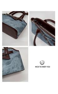 Close-up of vintage denim tote bag showing leather handles and silver metal zipper details