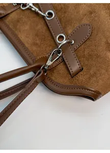 Detail of vintage brown bowling bag showing silver metal hooks and premium suede texture