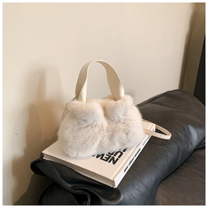 Vue détaillée du sac seau en fausse fourrure blanc crème avec poignée en cuir
