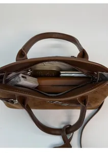 Detail view of brown suede crossbody shell bag showing spacious internal storage capacity