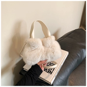 Détail d'un sac seau en fausse fourrure pelucheuse avec poignée en cuir chic