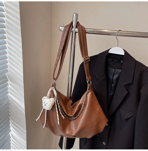 Détail du sac hobo en cuir PU marron avec chaîne en métal et breloque ours blanc