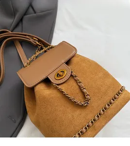 Detail of brown faux suede backpack with gold hardware lock and woven chain
