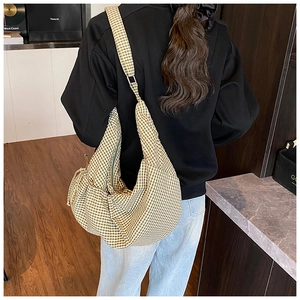 Back view of model wearing a large yellow plaid hobo bag with comfortable wide strap