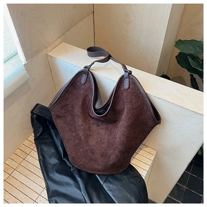 Detail of a large vintage brown frosted leather bucket bag on a wooden display stand