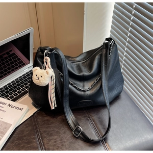 Vue détaillée du cuir PU noir avec chaîne argentée et breloque ours sur le sac cabas