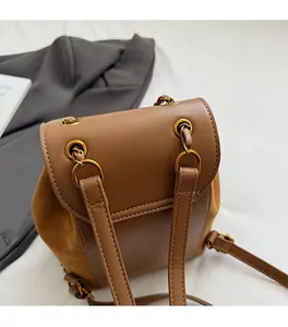 Close-up of premium gold hardware and mixed leather texture on a brown vintage backpack