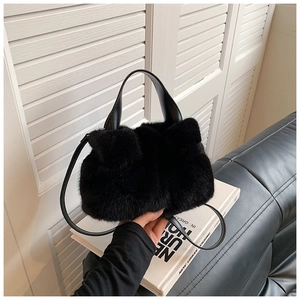 Détail de la texture en fausse fourrure et de la poignée en cuir du sac seau noir