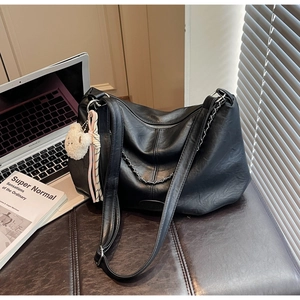 Détail du grand sac à bandoulière en cuir PU noir avec chaîne et breloque ours en peluche