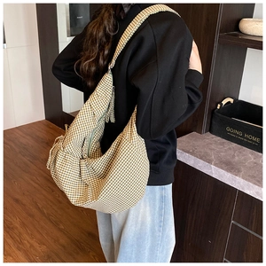 Brown and white gingham hobo bag shown on a model in a warm indoor home setting