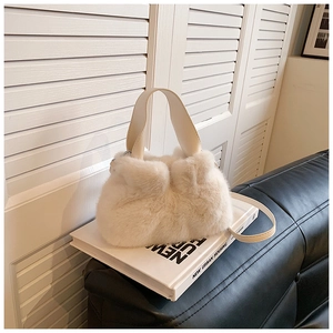 Détail de la texture d'un sac seau en peluche blanche avec doubles poignées de port