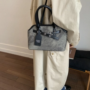Detailed view of gray vintage textured handbag with black leather straps and silver hardware