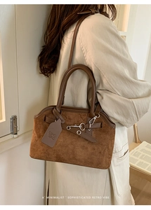 Detail of vintage brown suede handbag with metal buckle and branded CHIO 2ND tag