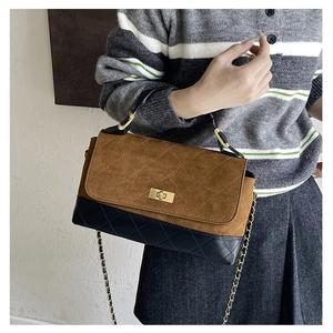 Detail of color-block shoulder bag with quilted texture and gold metal chain strap