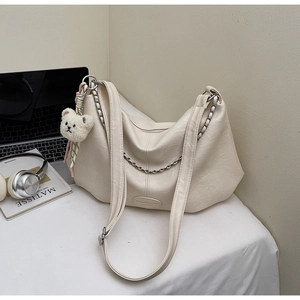 Détail du sac hobo crème avec chaîne argentée et pendentif ours en peluche doux