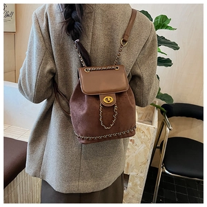 Detail of vintage brown mini backpack in matte leather with gold clasp on model