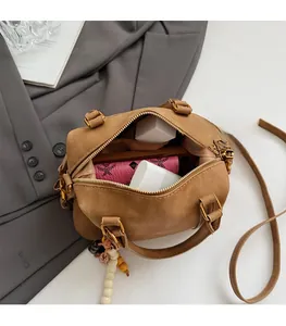 Interior view showing the large capacity of this brown suede Boston bag with accessories