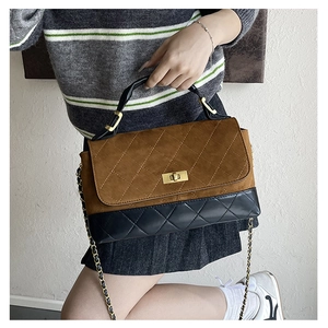 Close-up of matte quilted crossbody bag featuring contrast colors and metal chain strap