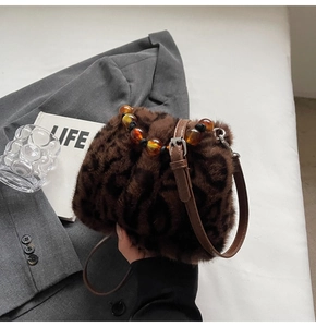 Detail der Eimer-Handtasche aus Leoparden-Kunstfell mit bernsteinfarbenem Perlengriff