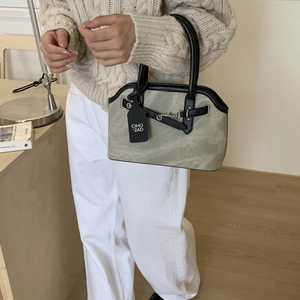 Detail of vintage gray crossbody bag with black leather handles and metal buckle accents