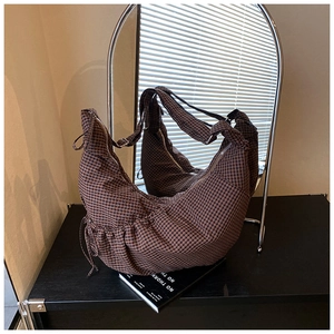 Detail of brown plaid hobo bag with adjustable strap and smooth silver zipper closure