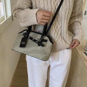 Close-up of retro crossbody bag with black leather straps and CIHO tag details